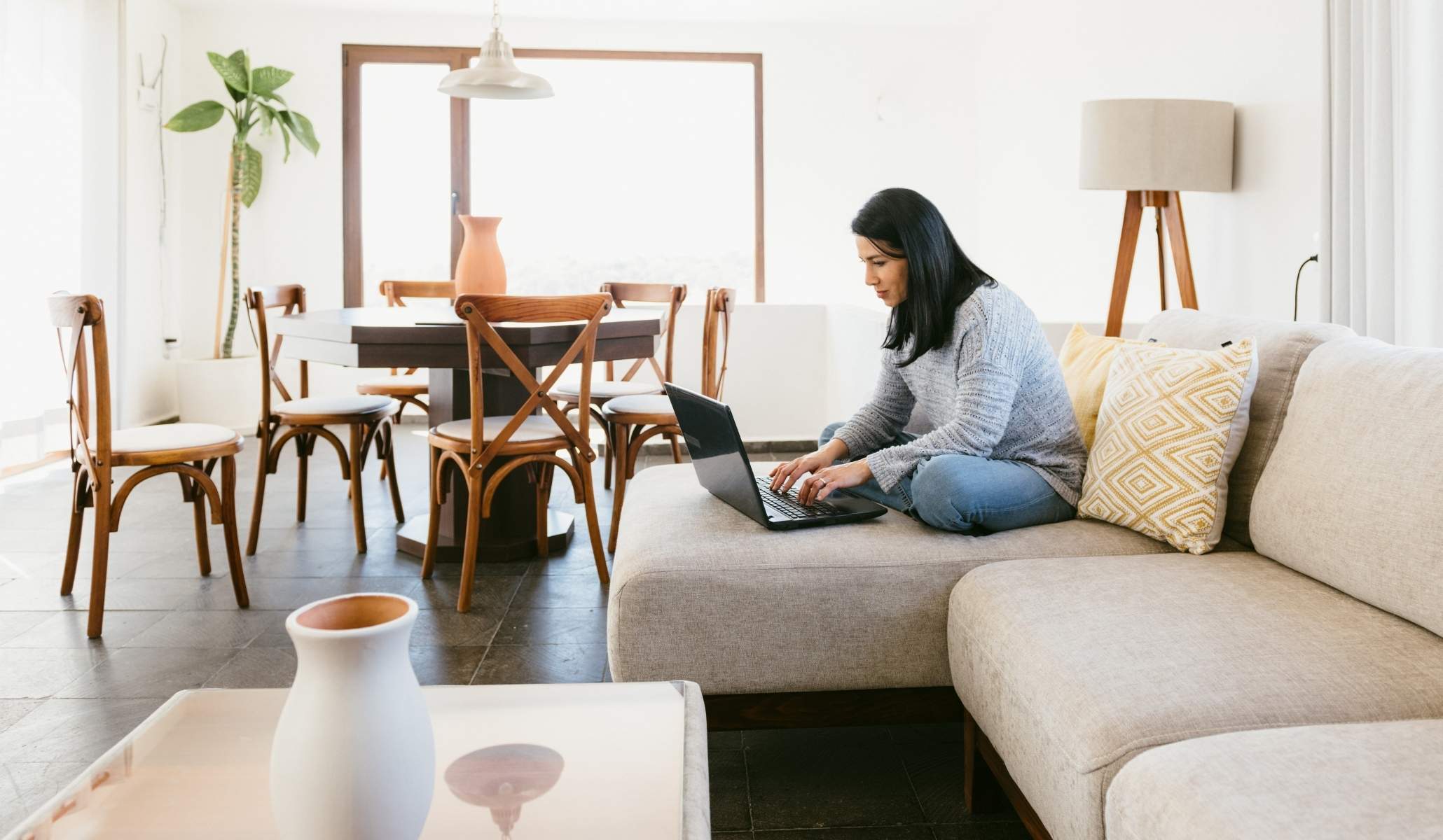 Femme travaillant sur canape dans salon