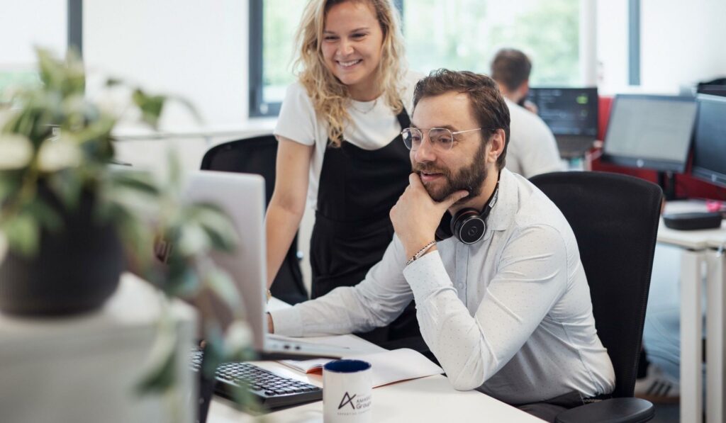 Collaborateurs immo en situation de travail qui discute devant ordinateur